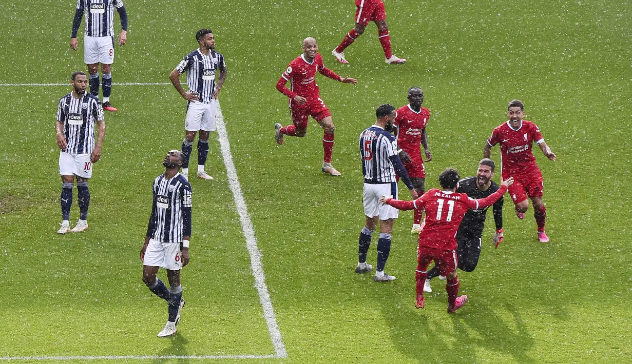 Kiper Liverpool, Alisson Becker, melakukan selebrasi usai mencetak gol ke gawang West Bromwich Albion pada laga Liga Inggris di Stadion the Hawthorns, Minggu (16/5/2021). Liverpool menang dengan skor 2-1. (Laurence Griffiths/Pool via AP)