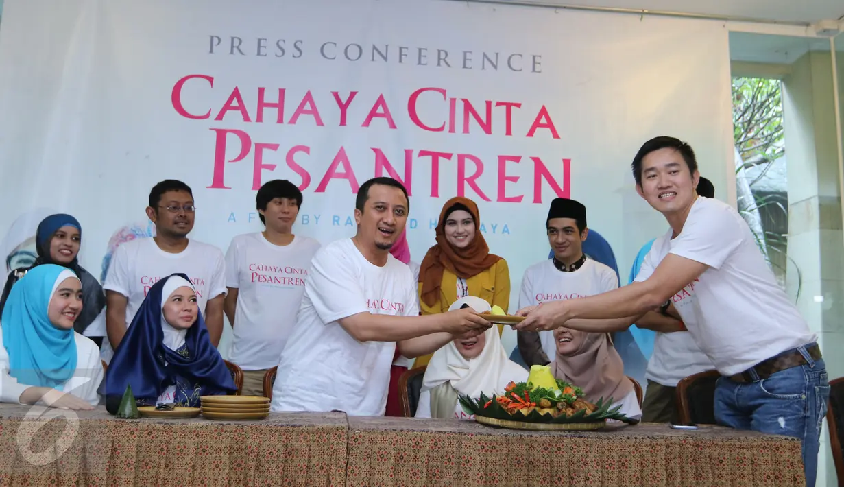 Ustadz Yusuf Mansur menerima potongan tumpeng saat menggelar konferensi pers film Cahaya Cinta pesantren, Jakarta, Senin (25/1/2016). Film ini diadaptasi dari novel karya Ira Madan. (Liputan6.com/Herman Zakharia)