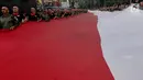 Anggota TNI POLRI  membawa bendera raksasa saat gelaran Festival Merah-Putih (FMP) 2018 di kawasan Air Mancur, Bogor,  Minggu (5/8). Kegiatan tersebut dalam rangka menyambut HUT Kemerdekaan RI ke-73. (Merdeka.com/Arie Basuki)