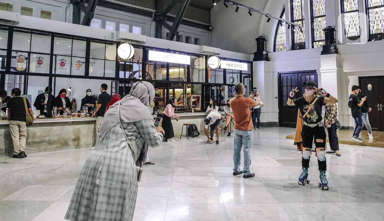 Pengunjung berfoto di area tengah Pos Bloc, Jakarta Pusat, Sabtu (9/10/2021). Selain menjadi tempat berdiskusi, Pos Bloc juga akan mewadahi beberapa sektor usaha kreatif. (Liputan6.com/Faizal Fanani)