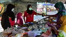 Orang-orang mengenakan masker saat membeli makanan di pasar menjelang berbuka puasa selama bulan suci Ramadan di Provinsi Narathiwat, Thailand, Selasa (5/5/2020). Ramadan kali ini berlangsung di tengah bayang-bayang virus corona COVID-19. (Madaree TOHLALA/AFP)