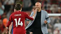 Pemain Liverpool, Federico Chiesa (kiri), merayakan kemenangan timnya atas Bournemouth bersama Arne Slot pada pekan 1 Premier League 2025/2026 di Anfied, Sabtu (16/8/2025) dini hari WIB. (Paul ELLIS / AFP)