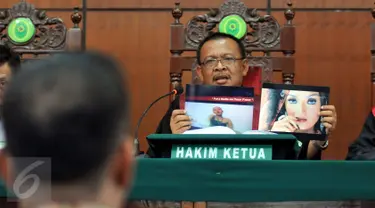 Sidang lanjutan dugaan pelanggaran hak cipta oleh PT Vista Pratama kembali digelar di Pengadilan Negeri Jakarta Utara pada Selasa (18/8/2015). Hakim Ketua tampak memperlihatkan barang bukti foto dalam sidang tersebut. (Liputan6.com/Panji Diksana)