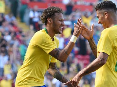 Striker Brasil, Neymar, merayakan gol yang dicetak Roberto Firmino ke gawang Kroasia pada laga persahabatan di Stadion Anfield, Liverpool, Minggu (3/6/2018). Brasil menang 2-0 atas Kroasia. (AFP/Oli Scarff)
