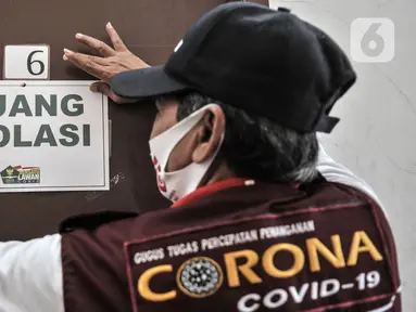 Anggota Lembaga Keswadayaan Masyarakat (LKM) memasang label pada pintu kamar isolasi COVID-19 di RW 05 Kelurahan Kuningan Barat, Jakarta, Kamis (27/8/2020). Pengubahan tempat indekos menjadi ruang isolasi tersebut atas dasar kepedulian terhadap sesama. (merdeka.com/Iqbal S. Nugroho)