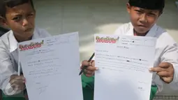 Murid MI Yayasan Nurul Bahri menunjukkan surat yang ditulis untuk Presiden Jokowi, di perkampungan nelayan Muara Angke, Jakarta, Senin (27/2). Kegiatan itu juga sebagai kepedulian pada dunia literasi untuk anak Indonesia. (Liputan6.com/Faizal Fanani)