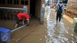 Warga mulai beraktivitas menyusul surutnya air yang sempat merendam pemukiman mereka di kawasan Kampung Pulo, Jakarta, Selasa, (17/11). (Liputan6.com/Gempur M Surya)