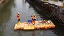 Petugas UPK Badan Air Pemprov DKI Jakarta membersihkan ceceran sampah di sepanjang Anak Sungai Ciliwung yang membelah kawasan Jalan Gajah Mada dan Hayam Wuruk, Selasa (9/7/2019). Pembersihan ini untuk menghindari penumpukan sampah dan memperlancar aliran air. (Liputan6.com/Helmi Fithriansyah)