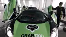 Seorang pengemudi GrabTaxi memeriksa taksi McLaren usai pemotretan dengan tujuh mobil mewah sebelum beroperasi di Singapura, Selasa (15/9). Mobil-mobil mewah itu akan melayani penumpang secara gratis selama musim balapan F1. (REUTERS/Edgar Su)