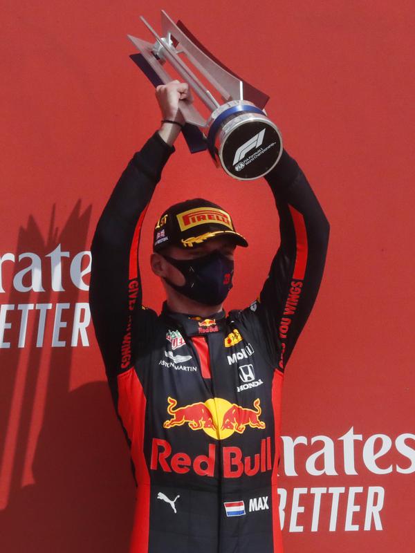 Pembalap Red Bull Max Verstappen mengangkat trofi usai memenangkan 70th Anniversary Formula 1 Grand Prix di Sirkuit Silverstone, Silverstone, Inggris, Minggu (9/8/2020). Max Verstappen sukses menjadi yang tercepat dalam F1 GP Silverstone 2020. (AP Photo/Frank Augstein, Pool)