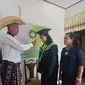 Foto : Adrianus Ndu Ufi didampinggi istri memindahkan tali toga milik anaknya, dr. Felin Aprilaineld Ndu Ufi, S.Ked saat wisuda virtual (Liputan6.com/Ola Keda)