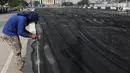 Petugas memasang jaring hitam di Kali Item, Kemayoran, Jakarta, Jumat (20/7). Pemasangan jaring tersebut merupakan cara Pemprov DKI mengatasi bau sebelum menerima atlet Asian Games 2018 yang akan menginap di Wisma Atlet. (Liputan6.com/Arya Manggala)