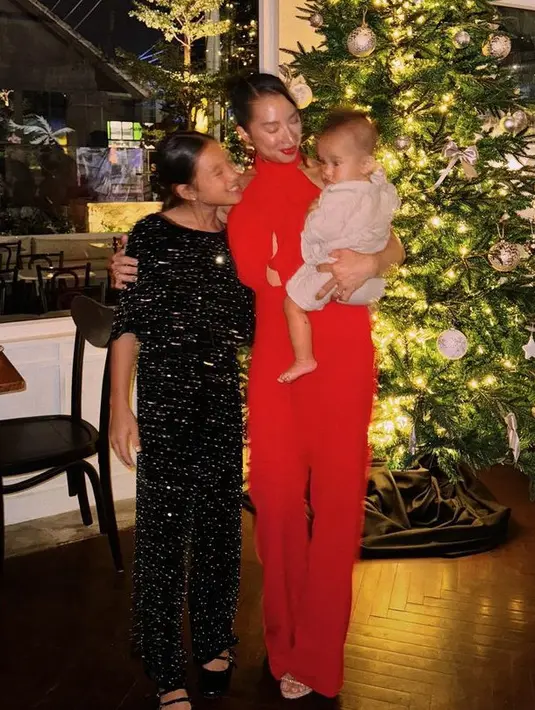 Jennifer pun memadukan jumpsuit merah tersebut dengan heels. Meski sedang menggendong anaknya yang paling kecil, namun ia tetap tampil stunning.  [@jenniferbachdim]