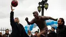 Wali Kota Horacio Larreta Rodriguez melempar bola di depan patung Lionel Messi yang baru diresmikan di Buenos Aires, Argentina, Selasa (28/6). Patung itu guna membujuk Messi membatalkan keputusan pensiun yang sudah diambilnya. (REUTERS/Marcos Brindicci)