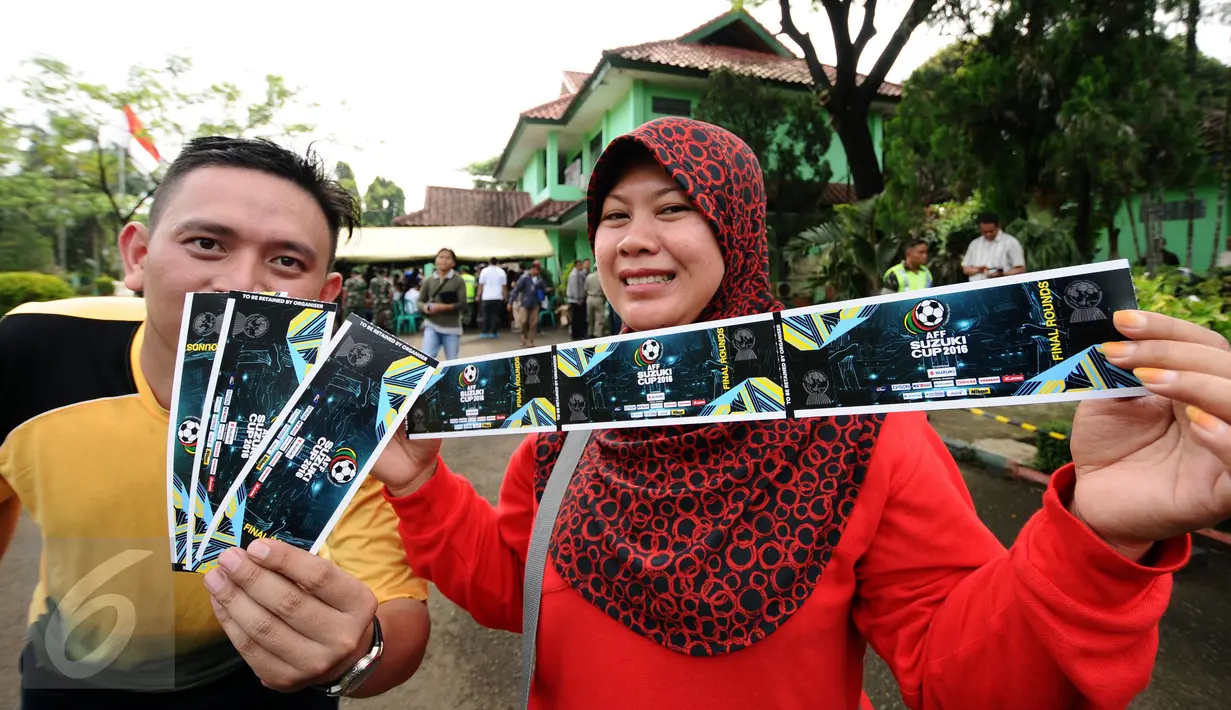 Calon suporter menunjukkan tiket final pertama Piala AFF 2016 di di halaman Kodim 0621 Surya Kancana Kab Bogor, Selasa (13/12). 5000 lembar tiket final pertama antara Indonesia melawan Thailand dijual di Kodim 0621. (Liputan6.com/Helmi Fithriansyah)