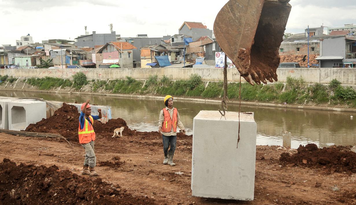 Pekerja memasang beton saluran air di proyek normalisasi Ciliwung, Bukit Duri, Jakarta, Rabu (8/2). Penyelesaian normalisasi Ciliwung mencakup pembangunan dinding parapet, sheetpile, jalan inspeksi maupun saluran air.(Liputan6.com/Yoppy Renato)
