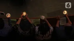 Jemaat menyalakan lilin saat mengikuti kebaktian malam Natal 2019 di Gereja Protestan Indonesia Bagian Barat (GPIB) Imanuel,  Jakarta, Selasa (24/12/2019). (Liputan6.com/Herman Zakharia)