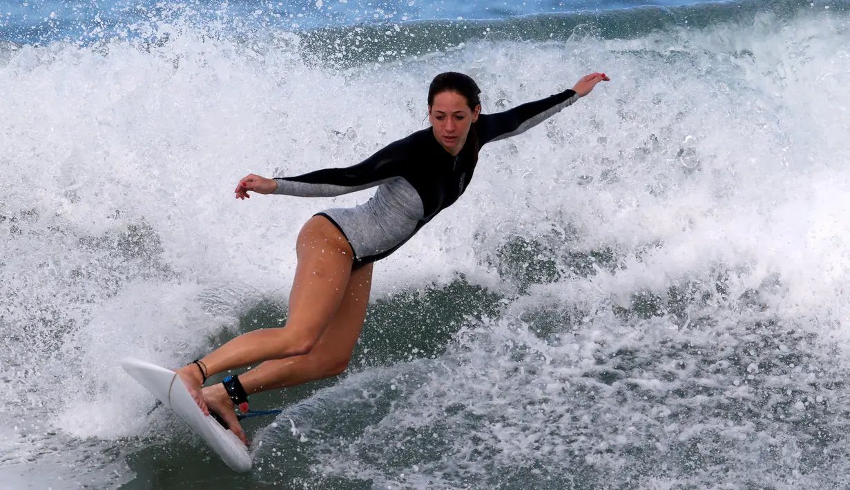 Peselancar wanita menunjukan aksinya menaklukan ombak selama mengikuti dalam kompetisi surfing di laut Mediterania di Ashdod, Israel, (17/11). (REUTERS/Amir Cohen)