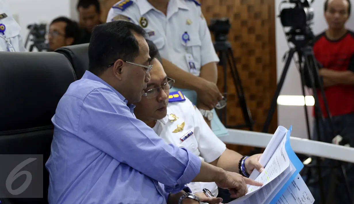 Menhub, Budi Karya Sumadi (kiri) melihat data saat melakukan teleconference di Kemenhub, Jakarta, Minggu (25/12). Menhub Budi Karya memastikan angkutan pada Natal 2016 dan Tahun Baru 2017 berjalan lancar. (Liputan6.com/Helmi Fithriansyah)