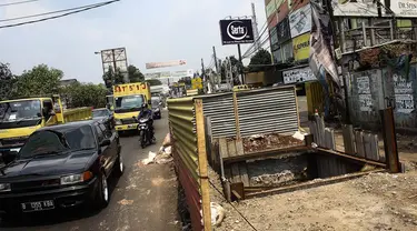 Sejumlah pengendara melintas di depan proyek galian sedalam 12 meter di Jalan Alternatif Cibubur, Jakarta, Senin (10/11/2014). (Liputan6.com/Faizal Fanani) 