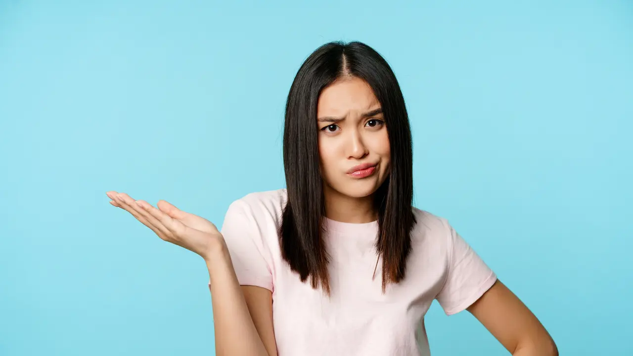 Seorang perempuan tampak keheranan sambil berkacak pinggang dan mengangkat satu tangan (Foto Dok: Freepik/benzoix)