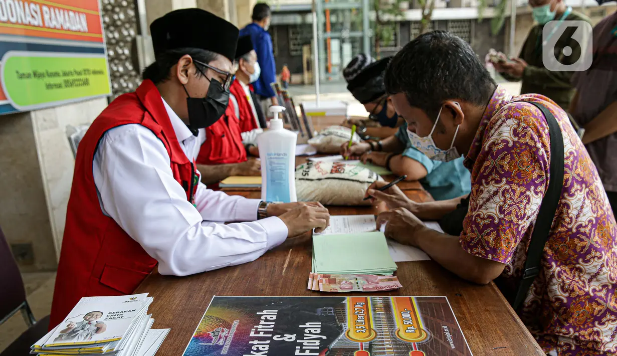 Umat muslim membayar zakat fitrah kepada amil zakat di Masjid Istiqlal, Jakarta, Jumat (7/5/2021). Panitia Zakat Masjid Istiqlal mulai membuka layanan pembayaran zakat fitrah dengan pembayaran senilai Rp 50 ribu atau 3,5 liter beras. (Liputan6.com/Faizal Fanani)