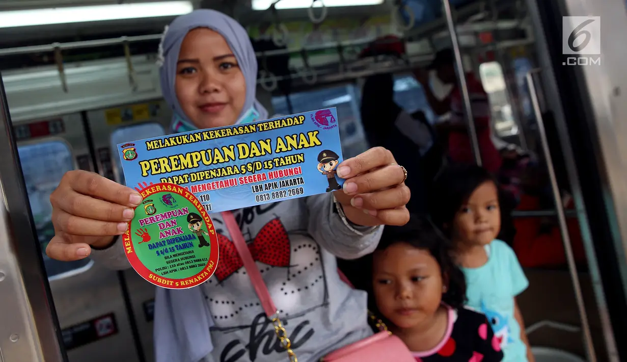 Seorang wanita menunujukkan stiker informasi pengaduan kekerasan di sekitar Stasiun Tanah Abang, Jakarta, Kamis (21/12). Stiker ini bertuliskan informasi tentang pengaduan ketika terjadi kekerasan pada wanita dan anak. (Liputan6.com/JohanTallo)