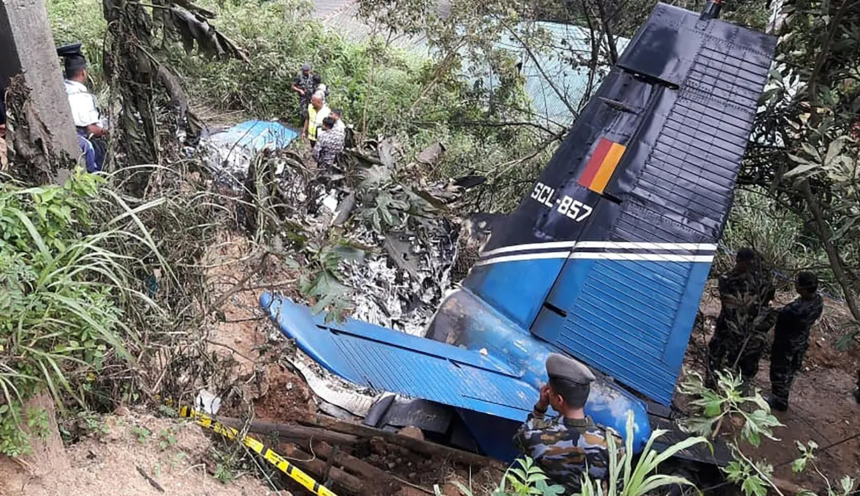 Pesawat Militer Sri Lanka Jatuh: Petugas penyelamat memeriksa puing-puing pesawat milik AU Sri Lanka yang jatuh di daerah pegunungan penghasil teh di Haputale, Jumat (3/1/2020). Pesawat Y-12 buatan China lepas landas dari pangkalan udara Wirawila menuju Ratmalana, selatan Kolombo. (STR / AFP)