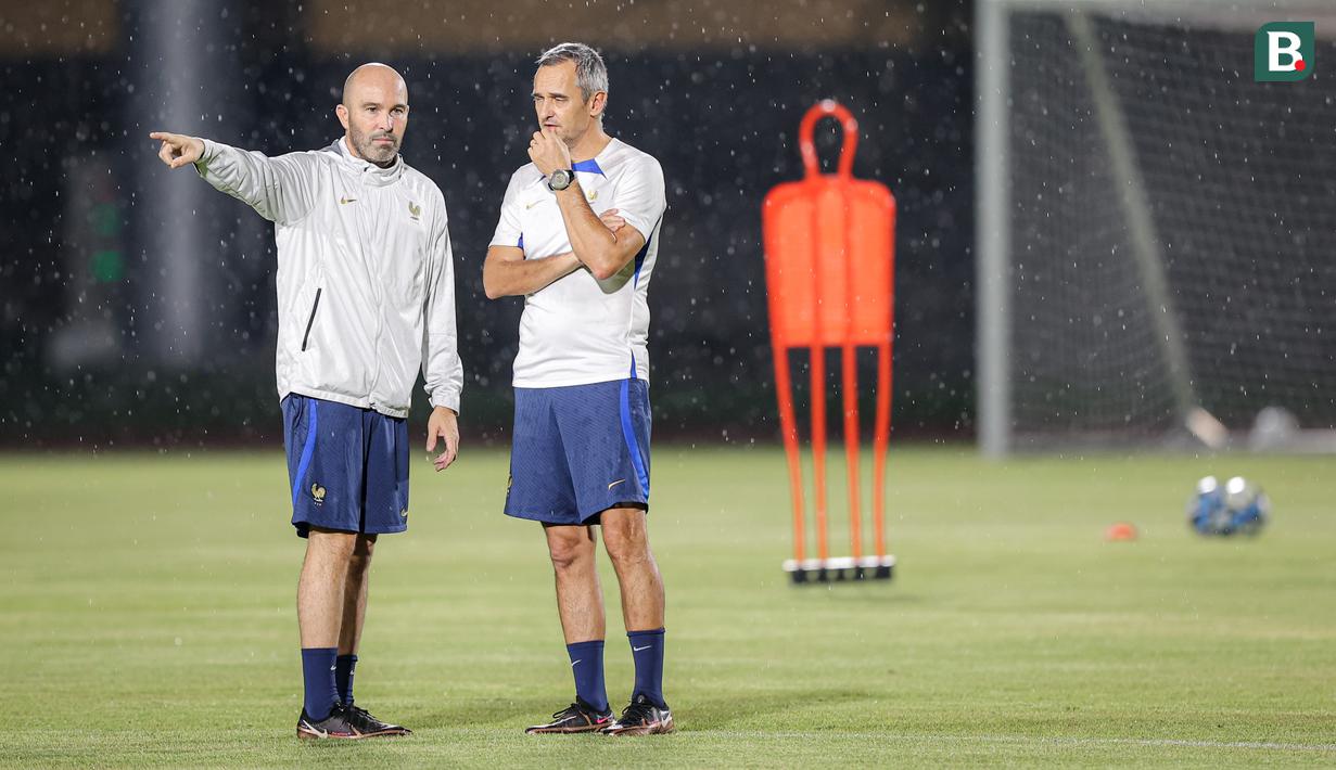 <p>Pelatih Timnas Prancis U-17, Jean Luc Vannuchi (kanan) berdiskusi dengan salah satu tim pelatihnya melakukan latihan di bawah hujan jelang laga final Piala Dunia U-17 2023 melawan Timnas Jerman U-17 di Stadion Sriwedari, Solo, Jawa Tengah, Kamis (30/11/2023). (Bola.com/Bagaskara Lazuardi)</p>