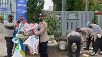 Beberapa anggota Polres Garut nampak sigap melaksanakan pembersihan sampah di lokasi bekas aksi demo mahasiswa 11 April depan gedung DPRD Garut. (Liputan6.com/Jayadi Supriadin)