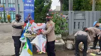 Beberapa anggota Polres Garut nampak sigap melaksanakan pembersihan sampah di lokasi bekas aksi demo mahasiswa 11 April depan gedung DPRD Garut. (Liputan6.com/Jayadi Supriadin)