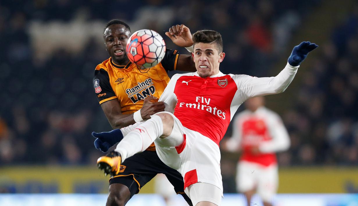 Pemain Arsenal, Gabriel Paulista, berebut bola dengan pemain Hull City, Moses Odubajo, dalam partai ulang putaran kelima Piala FA di Stadion KC, Hull City, Rabu (9/3/2016) dini hari WIB. (Action Images via Reuters/Carl Recine)