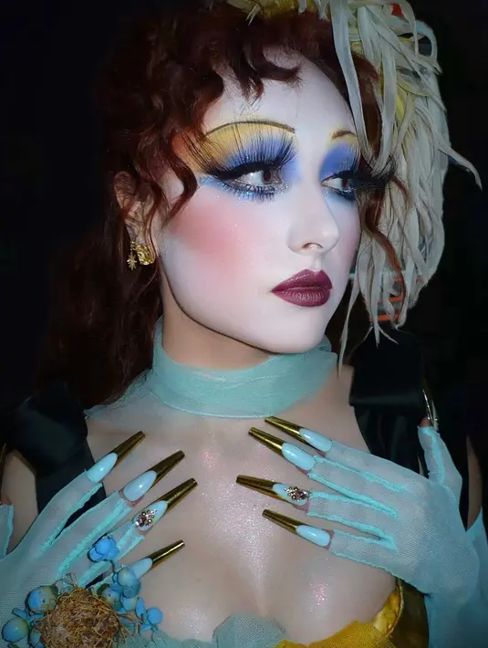 Manikurnya pun tidak kalah mencuri perhatian,menampilkan kombinasi French tips berlapis emas chrome dengan dasar biru pastel yang dihiasi aksen permata.  [@genesiswbb].