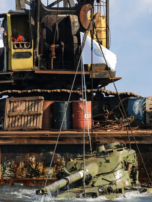 Aktivis lingkungan menenggelamkan sebuah tank lama ke dasar Laut Mediterania di lepas pantai kota pelabuhan Sidon, Lebanon, Sabtu (28/7). Mereka menenggelamkan 10 tank lama yang disediakan oleh Angkatan Bersenjata Lebanon. (AFP / Mahmoud ZAYYAT)