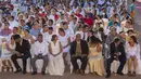 Pasangan duduk bersama saat pernikahan massal pada Hari Valentine di Managua, Nikaragua, Selasa (14/2/2023). Acara tersebut diselenggarakan oleh stasiun radio Sandinista "La Nueva Radio Ya", dan sekitar 263 pasangan menikah di Lapangan Revolusi. (AP Photo/Inti Ocon)