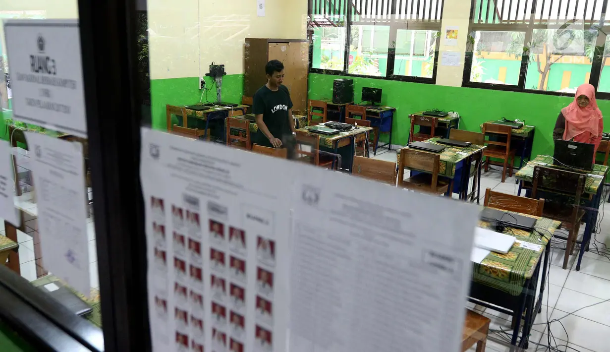Petugas mengecek kesiapan laptop dan ruang untuk Ujian Nasional Berbasis Komputer di SMP N 34 Pademangan, Jakarta Utara, Minggu (22/4). UNBK SMP 2018 akan berlangsung mulai besok Senin (23/4). (Liputan6.com/Johan Tallo)