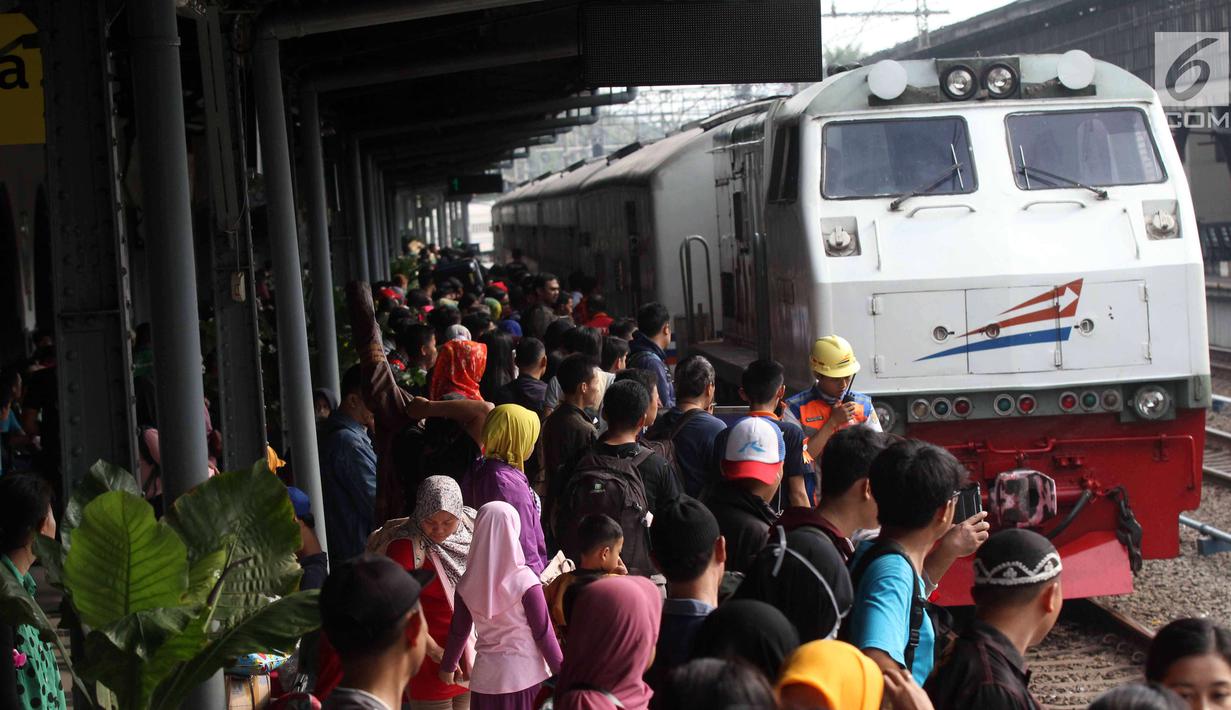 Peserta mudik gratis bareng PDIP bersiap menaiki kereta api di Stasiun Pasar Senen, Jakarta, Selasa (12/6). Mudik garatis ini dengan tujuan Stasiun Surabaya, Malang, Yogyakarta, dan Semarang. (Liputan6.com/Angga Yuniar)