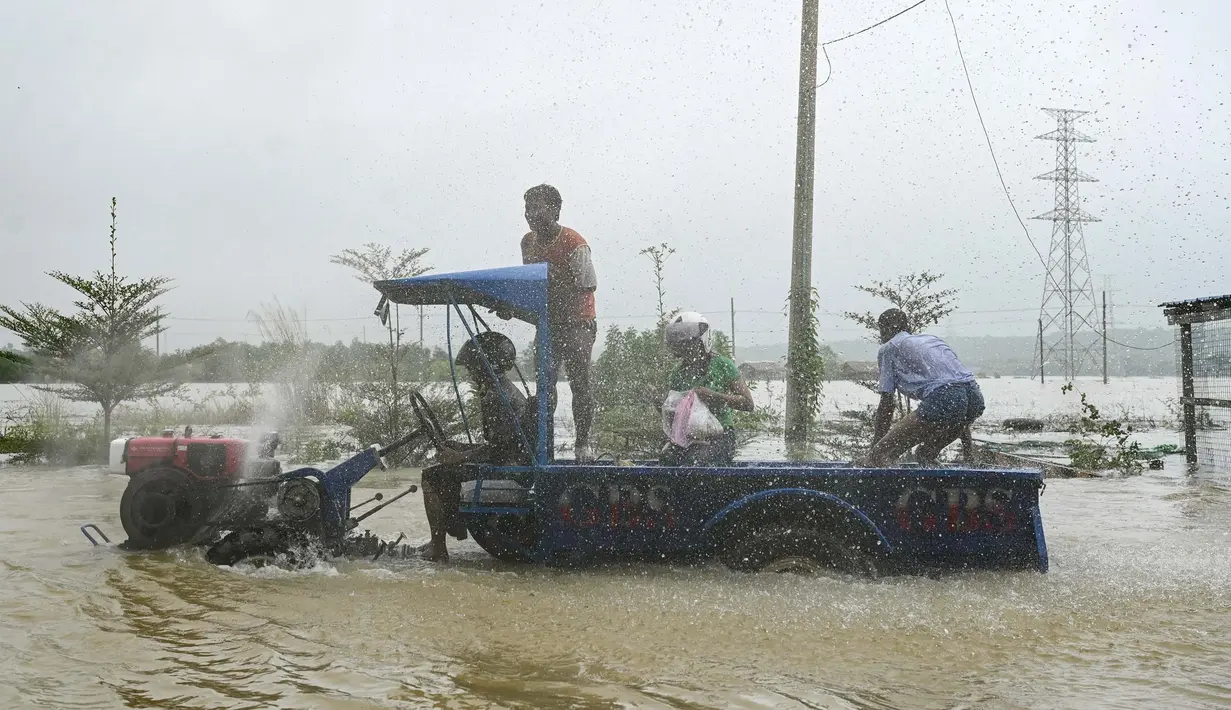 Warga menggunakan traktor untuk melintasi jalan yang tergenang banjir di kota Hpa Yar Gyi di wilayah Bago, Myanmar, pada tanggal 9 Oktober 2023. (SAI AUNG MAIN/AFP)
