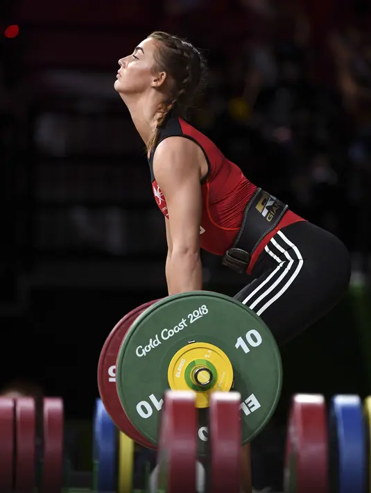 Holly Knowles dari Wales bersiap mengangkat beban saat berkompetisi dalam angkat besi wanita 63 kg selama Commonwealth Games 2018 di Gold Coast, Australia (7/4). (AFP Photo/William West)