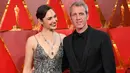 Aktris Gal Gadot didampingi suaminya, Yaron Varsano berpose di karpet merah Piala Oscar 2018, Los Angeles, Minggu (4/3). Meski film 'Wonder Woman' tak dijagokan di ajang bergengsi ini, Gal Gadot datang sebagai presenter. (ANGELA WEISS / AFP)