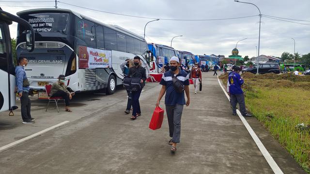 Sejumlah pemudik mulai mendatangi bus yang akan digunakan menuju kota tujuan pemudik melalui program mudik gratis di Terminal Jatijajar, Kota Depok. (Liputan6.com/Dicky Agung Prihanto)