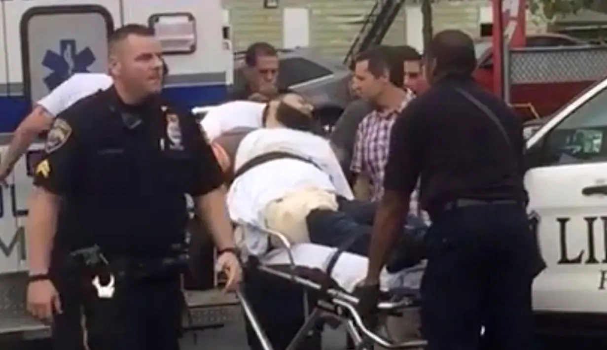 Petugas membawa Ahmad Khan Rahami ke dalam mobil ambulan di Linden, New Jersey, (19/9). Ahmad Khan Rahami, tersungkur ditanah setelah dilumpuhkan dalam adegan tembak menembak dengan polisi. (REUTERS/Anthony Genaro)