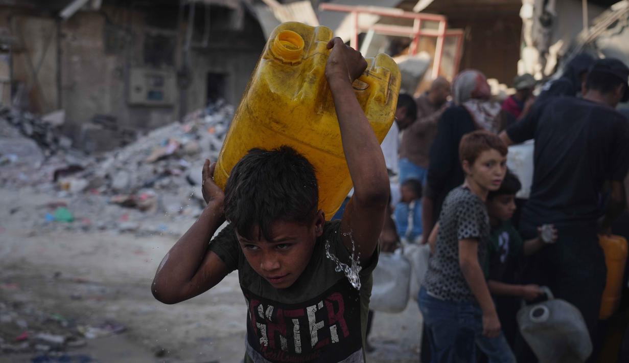 Warga Palestina membawa jerigen berisi air yang mereka kumpulkan dari sebuah truk di Kota Gaza, Kamis 16 Oktober 2025. (AP Photo/Jehad Alshrafi)