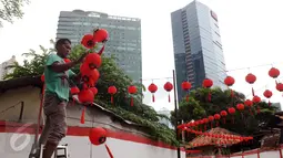 Pekerja memasang lampion di Vihara Amurva Bhumi, Jakarta, Minggu (31/1/2016). Pemasangan lampion jelang perayaan Tahun Baru Imlek 2567 merupakan simbol pengharapan keberkatan dan keberuntungan di tahun mendatang. (Liputan6.com/Helmi Fithriansyah)