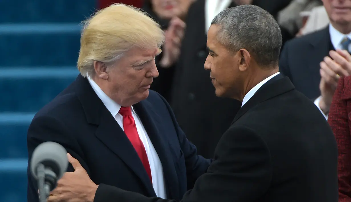 Barack Obama menyalami Donald Trump jelang penyampaian pidato pertama Trump sebagai Presiden AS di Capitol Hill, Washington DC, AS, Jumat (20/1). Dikabarkan, Trump sendiri yang menulis dan menyusun pidato pelantikannya. (AFP Photo)