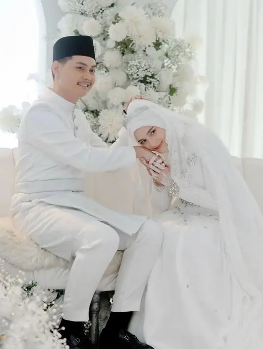 Sebagai pelengkap penampilannya, Yasmine memilih hijab putih senada yang dibentuk dengan sempurna sehingga menyatu harmonis dengan gaun pengantinnya. [@yxsmine.ow].