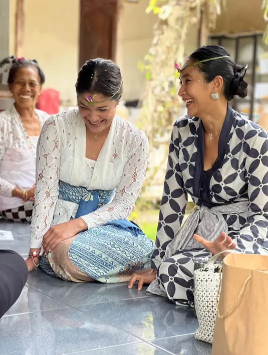 Happy Salma juga sering terlihat mengenakan kebaya Bali di momen lainnya, seperti saat pembacaan Wuku ini. Di sini, Happy Salma mengenakan kebaya bermotif bunga 4 kelopak berwarna bernuansa biru-putih dan selendang abu-abu. Ia juga terlihat memakai daun yang dililitkan di kepalanya. Foto: Instagram.