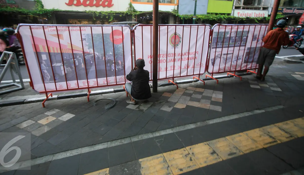 Sejumlah pekerja memasang pagar pembatas di kawasan pedestrian Malioboro, Senin (4/4). Terhitung sejak 4 April, kawasan Malioboro bebas dari parkir yang direlokasi ke Taman Parkir Abu Bakar Ali. (Liputan6.com/Boy Harjanto)