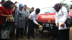 Menteri Pertanian Amran Sulaiman memecah kendi pada kendaraan Toko Tani Indonesia di TTI Center, Jakarta Selatan, Senin (6/2). Kementan melakukan pengiriman perdana komoditas pangan strategis ke 22 TTI yang tersebar di Jakarta. (Liputan6.com/Helmi Afandi)