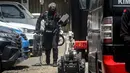 Polisi sudah mengkonfirmasi bahwa benda tersebut bukan bahan peledak dan mengatakan penyelidikan sedang dilakukan terkait upaya intimidasi publik menjelang Natal. Tampak dalam foto, seorang petugas polisi dari unit penjinak bom (Jibom) satuan Brimob Polda Jabar menyiapkan robot untuk membantu unit penjinak bom yang menyelidiki benda mencurigakan berbentuk kotak yang dibungkus lakban hitam dengan kabel di depan Gereja Kristen Protestan Simalungun (GKPS) di Bandung, Jawa Barat pada Jumat 19 Desember 2025. (Timur Matahari/AFP)